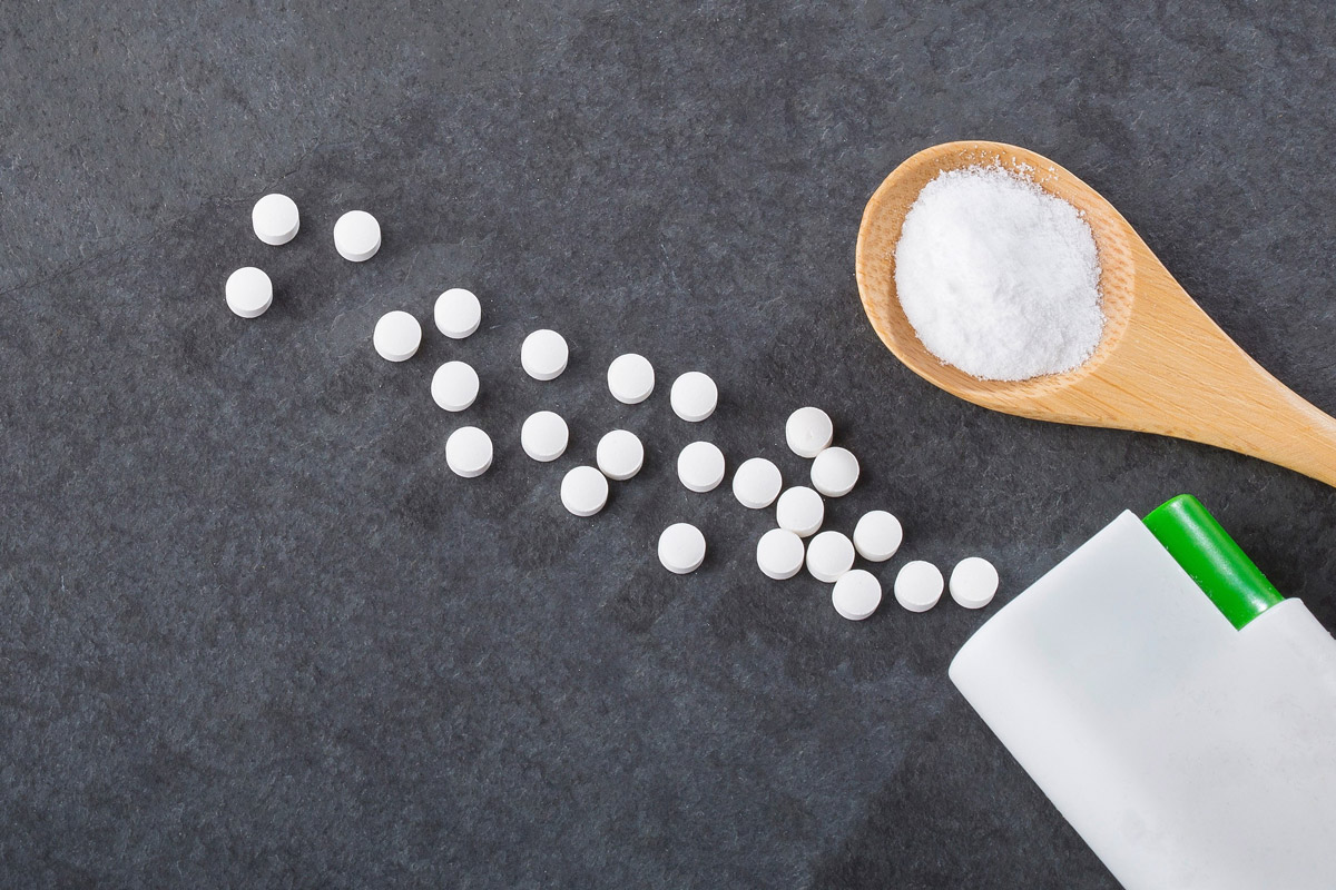 Sweetener tablets scattered on gray background