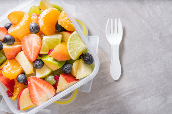 Fruit salad in recyclable plastic box with plastic fork