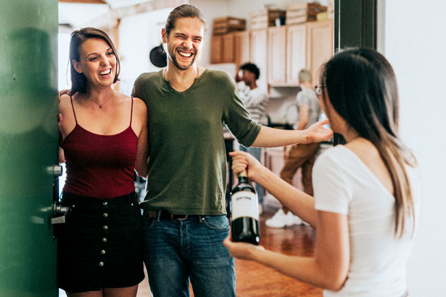 Guest is greeted by laughing couple