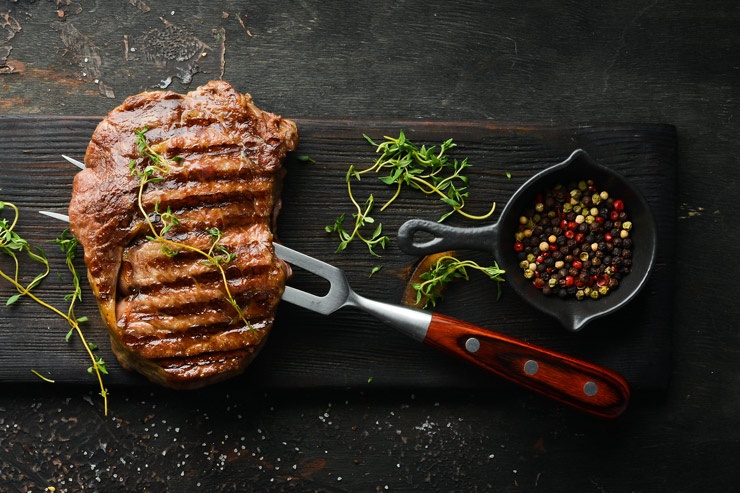 Grilled ribeye steak, fresh herbs and various peppercorns