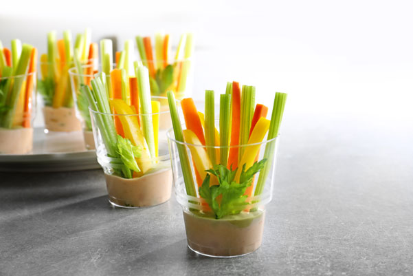 Glasses filled with dip and vegetable sticks
