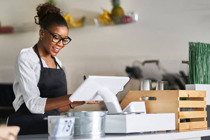 Laughing woman taps something into cash register