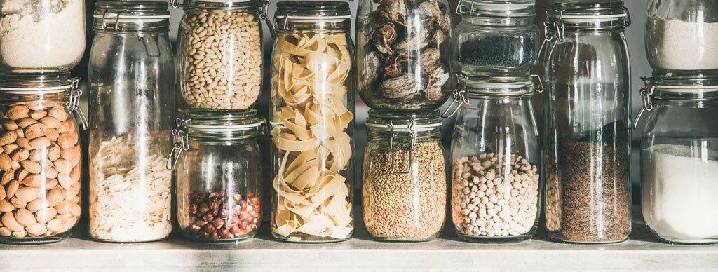 Glass storage container with grains, cereals, nuts, dried fruits flour and pasta