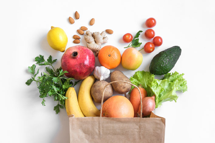 Paper bag filled with fruits, vegetables and fruits as a symbol of natural nutrition