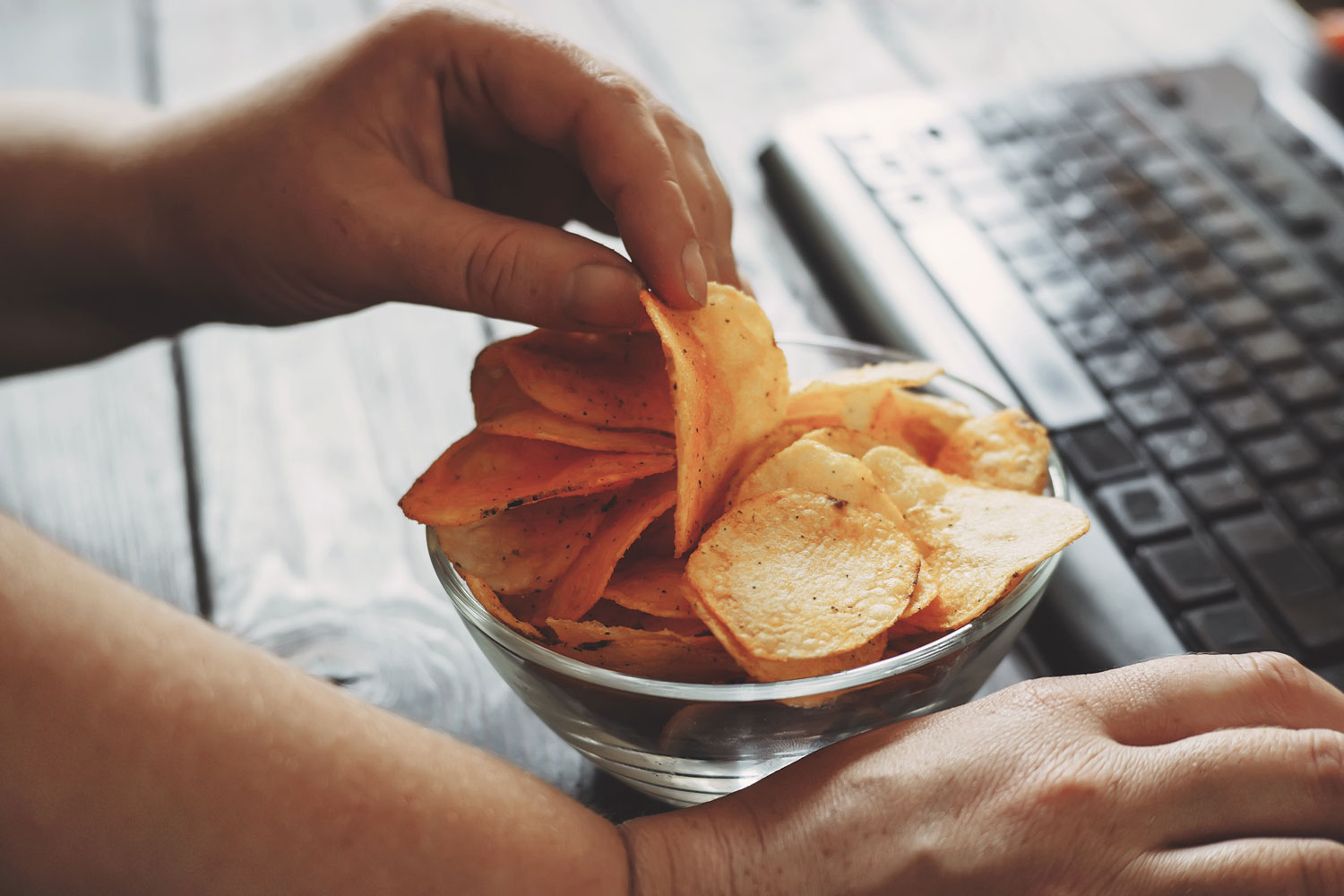 Hand takes chips from a bowl