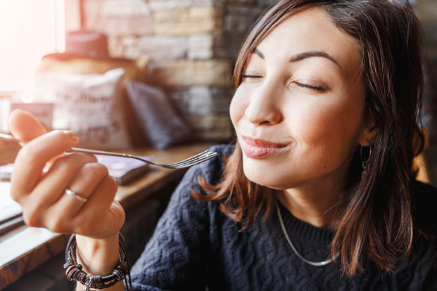 Dinner Date Close up of woman eating something with fork with pleasure