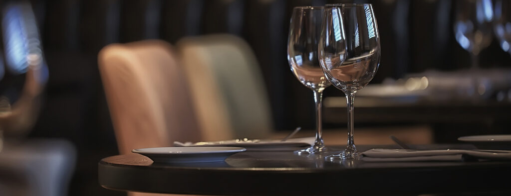 Dinner Date Two empty wine glasses on a laid dining table