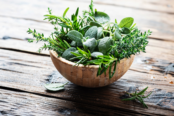 Infused Water A wooden bowl filled with various fresh herbs