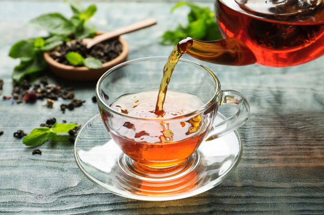 Tea is poured into a cup