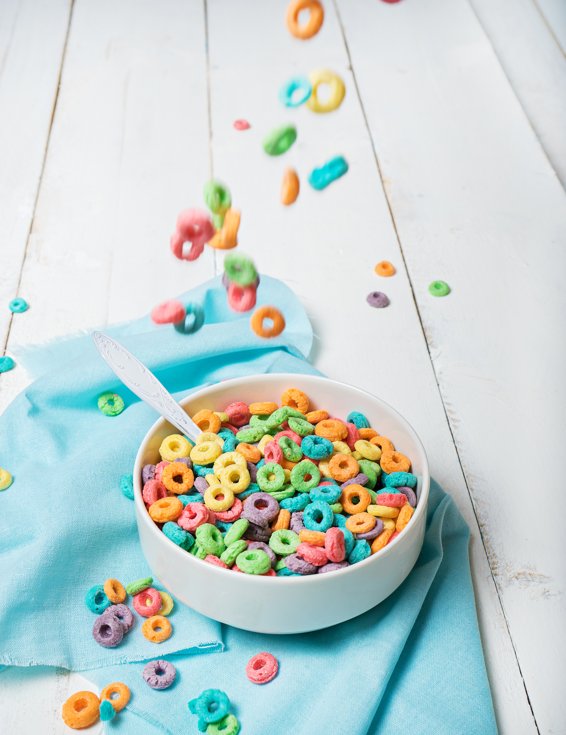 blog Colorful cereal falling on white bowl on a white background and textile