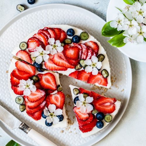 Fruity strawberry cake richly decorated with blueberries and cherry blossoms